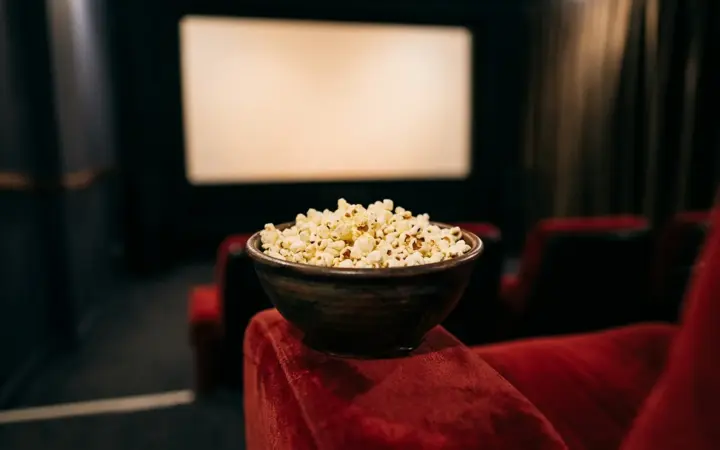 Popcorn and a velvet seat in a small private cinema (illustrative AI image)