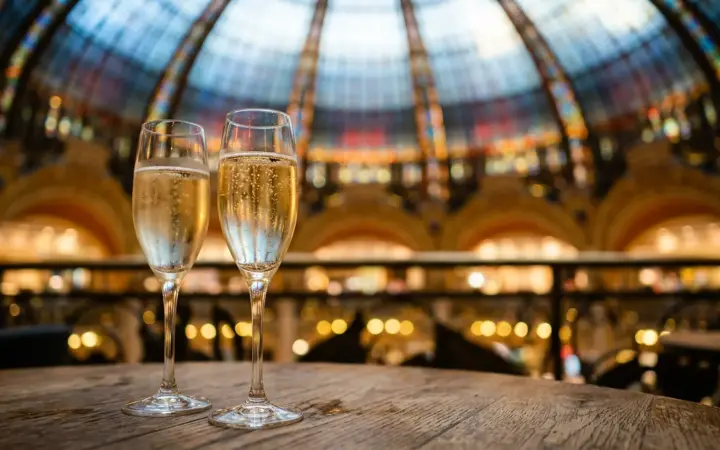 Champagne glasses under a stained-glass dome (illustrative AI image)